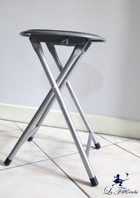 Tabouret pliant avec une assise abîmée