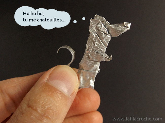 Rat origami tenu entre mes doigts qui pense Hu hu hu tu me chatouilles