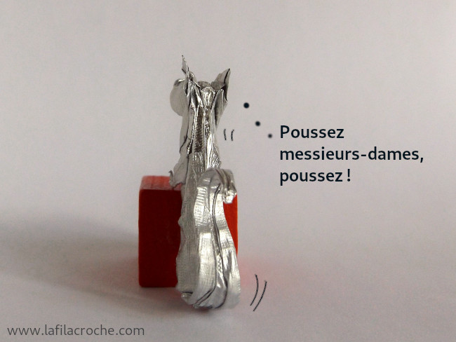 Vue de dos du rat origami qui pousse son bloc, il pense Poussez messieurs-dames, poussez !