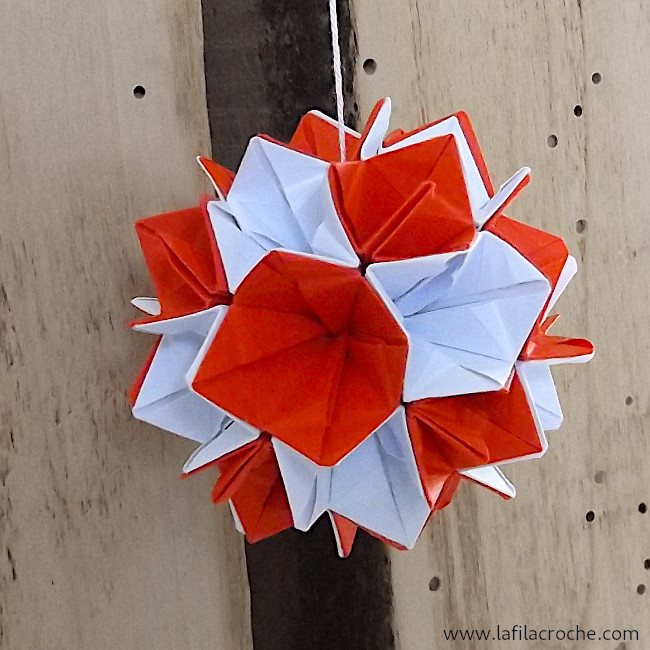 Kusudama de fleurs clochettes suspendu contre un montant en bois