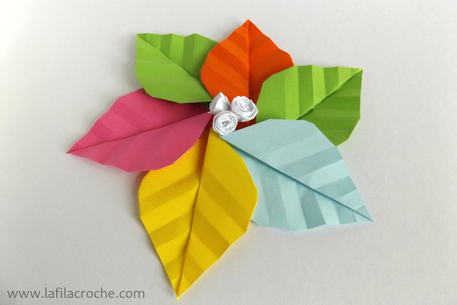 Arrangement en rond de 6 feuilles nervurées en origami avec 3 petites fleurs en papier roulé disposées au centre