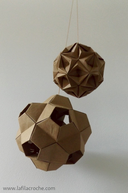 Deux kusudamas en origami suspendus le long d’un mur