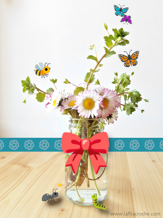 Un bouquet de pâquerettes et de véroniques dans un petit pot de verre