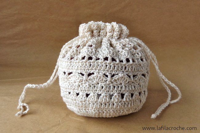 Bourse ronde au crochet en fil écru avec un point ajouré mais pas trop non plus