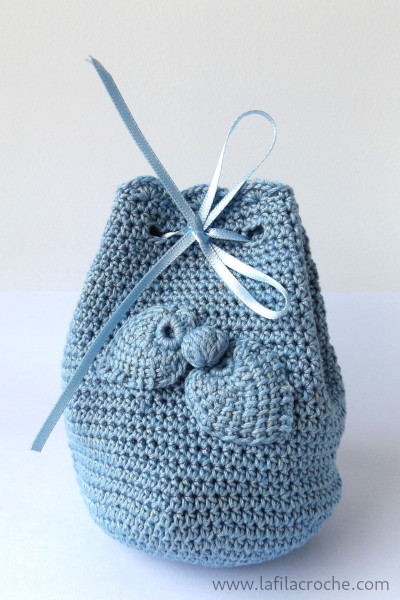 La même bourse en demi-brides ornée de deux feuilles et d’une boule crochetées et cousues sur le devant
