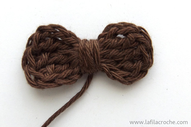 Le nœud au crochet est terminé en enroulant plusieurs fois le fil de fin autour de son milieu.