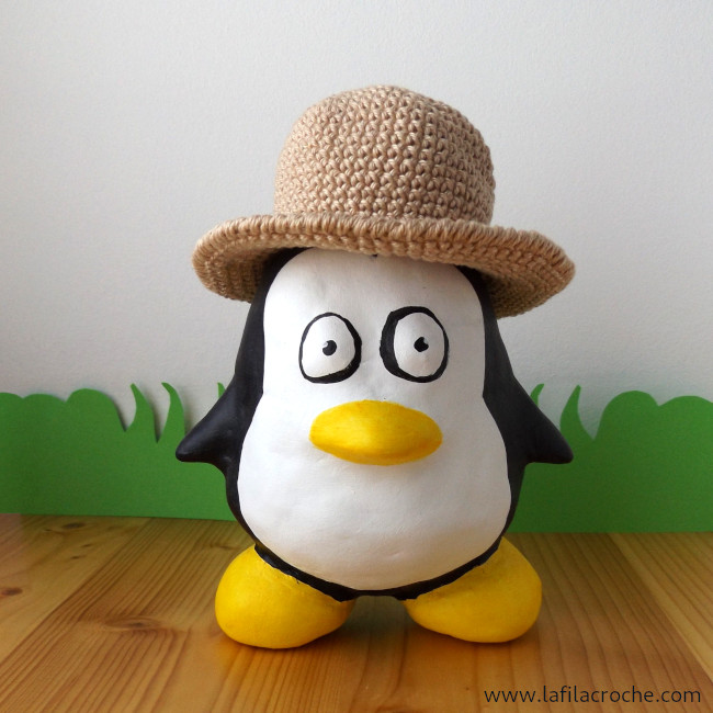 Une figurine du manchot Tux, la mascotte de Linux, avec mon chapeau au crochet sur sa tête.
