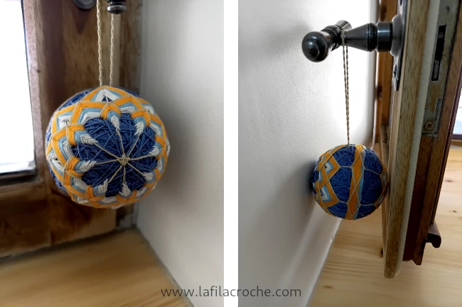 Balle temari accrochée à la poignée d’une fenêtre pour l’empêcher de faire des marques sur le mur