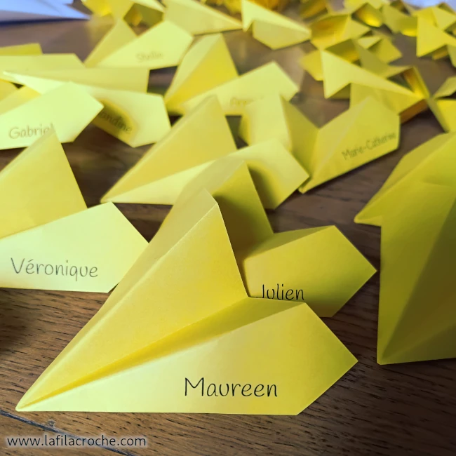 Des avions en papier avec des prénoms imprimés sur les ailes